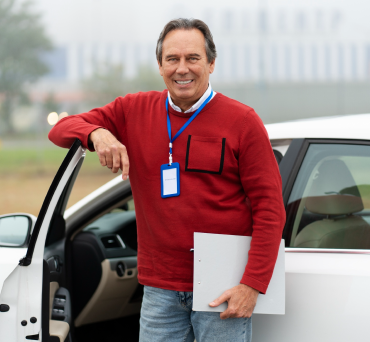 A Man Standing In From Of A Car